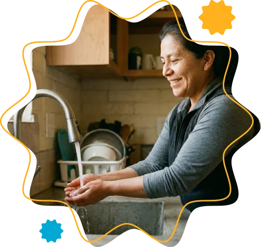 Mujer lavando con su nueva conexión de agua